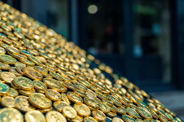 Moedas empilhadas formando uma escada ascendente em frente a uma loja de franquia desfocada.